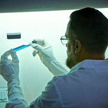 A lab technician holding a vial